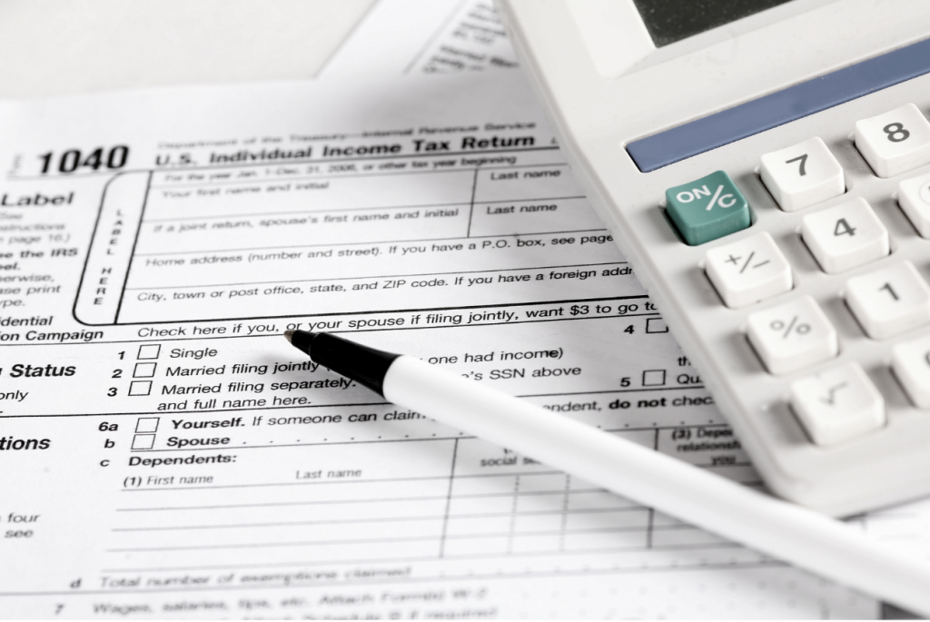 Tax return form 1040, a calculator, and a pen